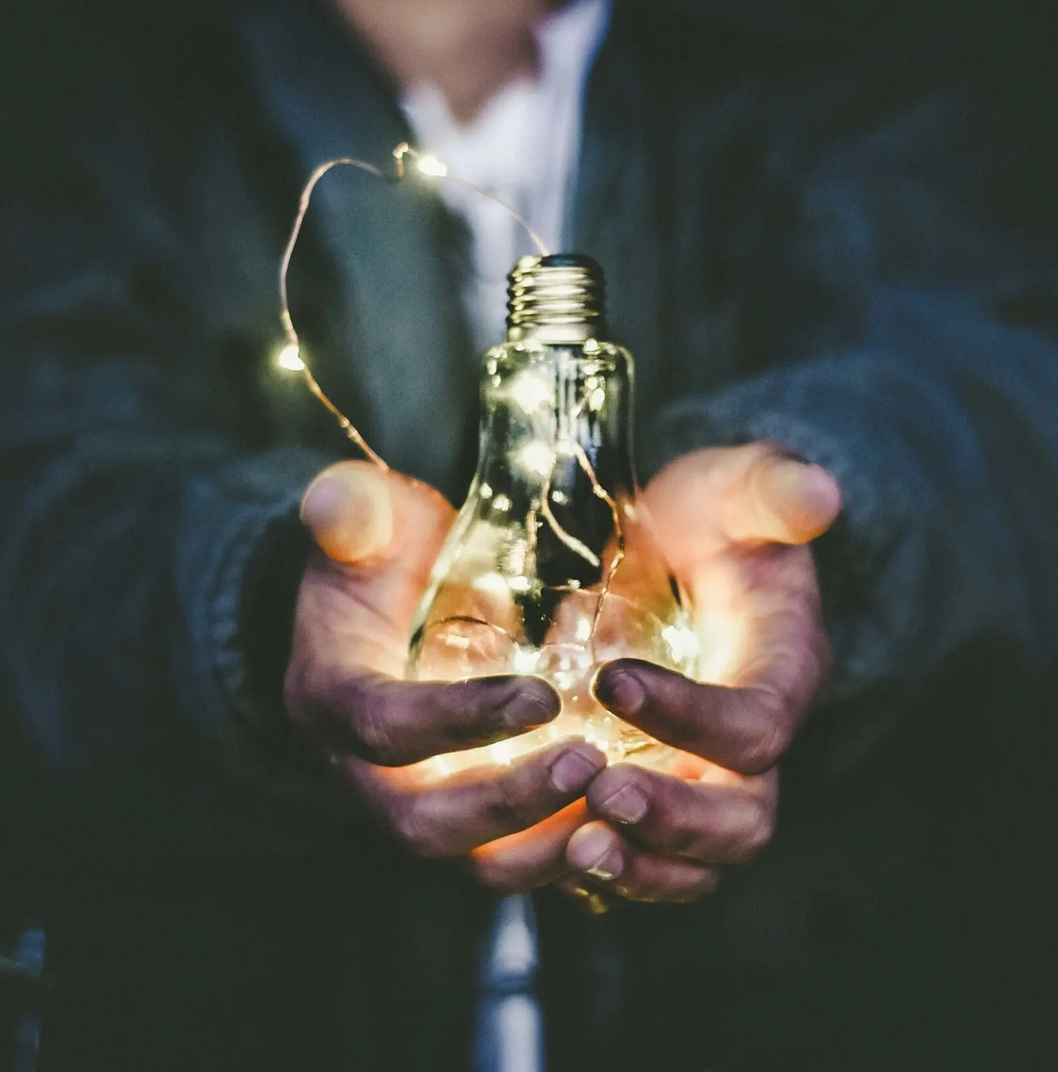 man holding incandescent bulb