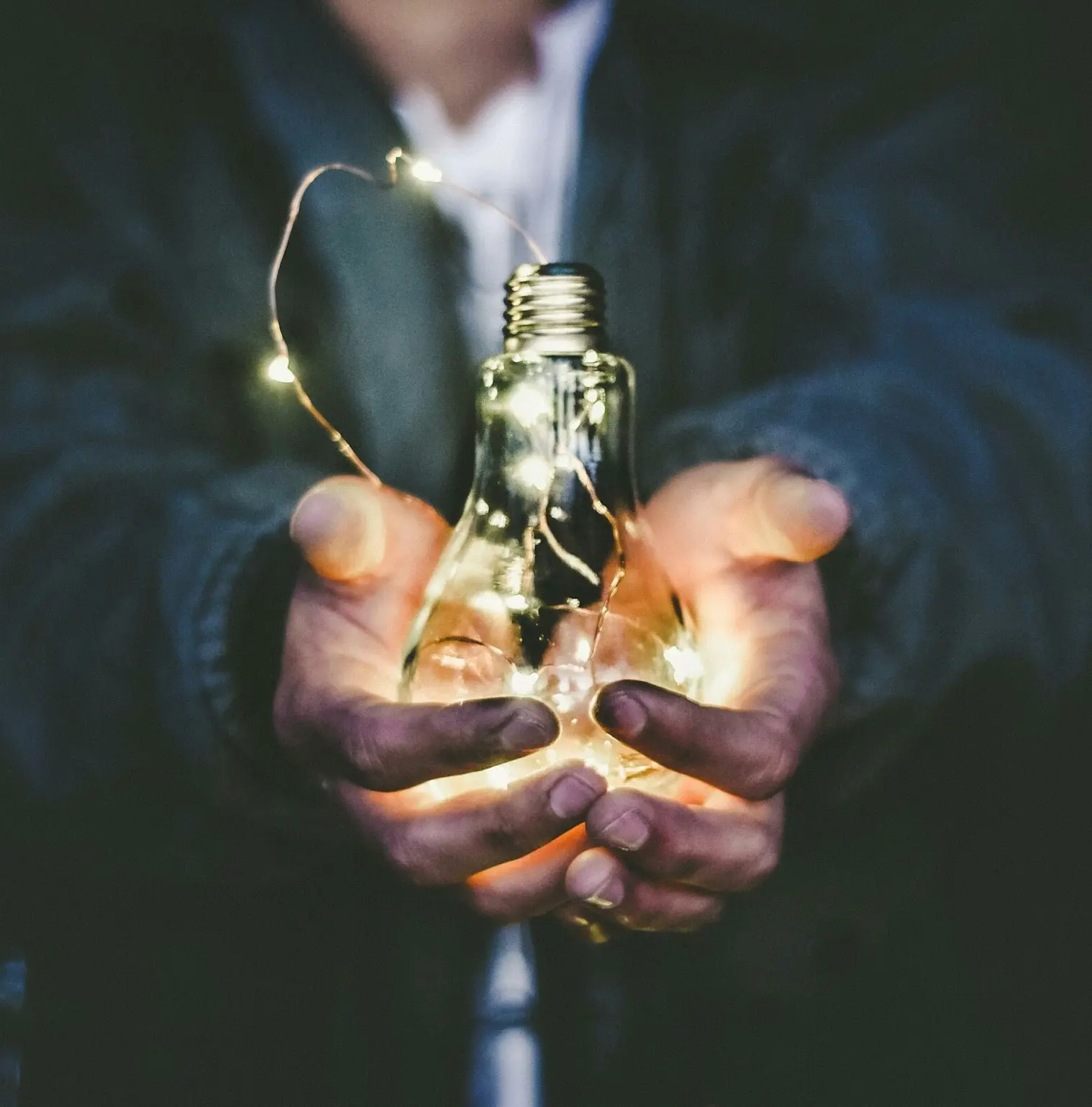 man holding incandescent bulb